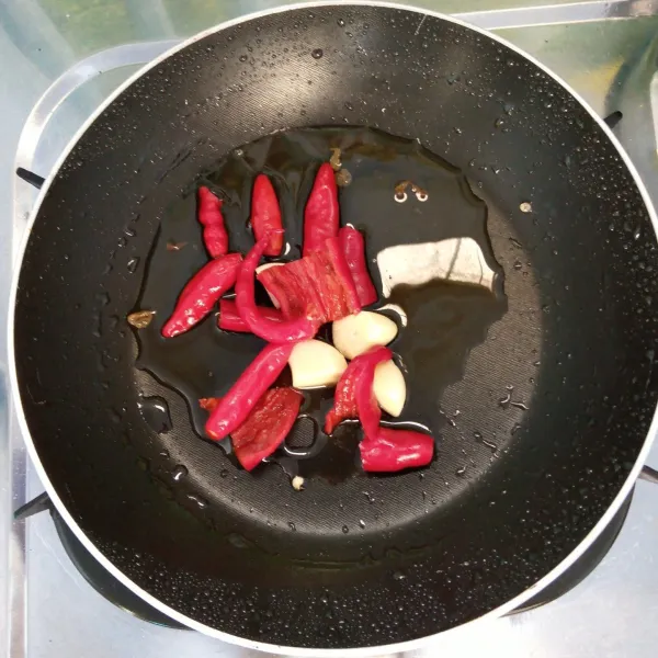 Goreng bawang putih, cabai merah dan cabai rawit sampai layu.