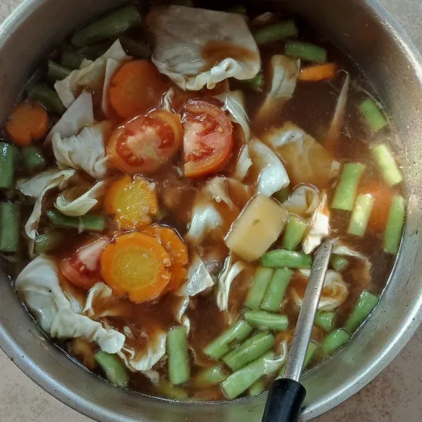 Masukkan kubis, tomat, garam, gula dan merica bubuk. Masak hingga matang.