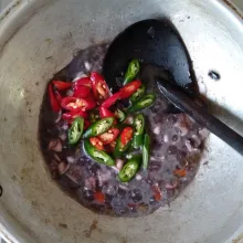 Setelah mendidih, masukkan cabai merah besar dan cabai hijau besar. Tumis sebentar. Cek rasa dan setelah pas, matikan api kompor. Baby cumi hitam siap dihidangkan.