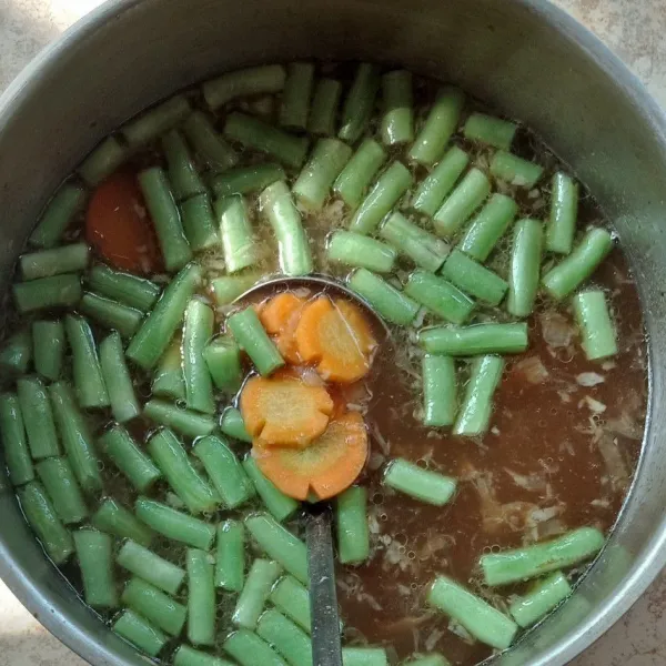 Masukkan wortel dan buncis, masak hingga setengah matang.