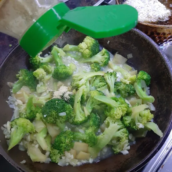 Setelah brokoli layu, masukkan kaldu jamur lalu garam, aduk-aduk
