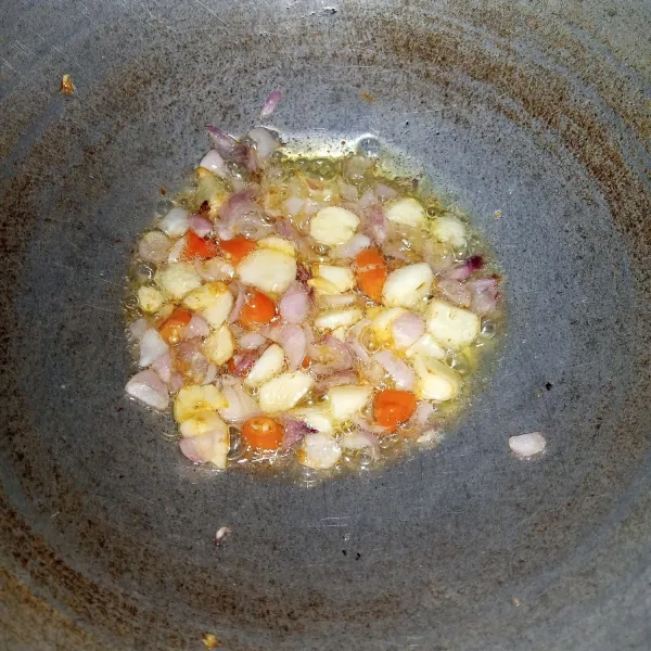 Tumis bawang merah dan bawang putih sampai layu. Masukkan cabai rawit. Aduk rata. Buang minyaknya.