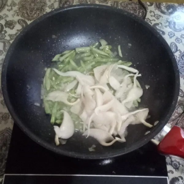 Tambahkan jamur tiram dan air. Aduk rata.