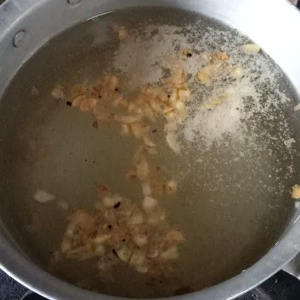 Panaskan air. Tambahkan bawang putih yang sudah di goreng. Tambahkan juga merica bubuk dan garam halus.