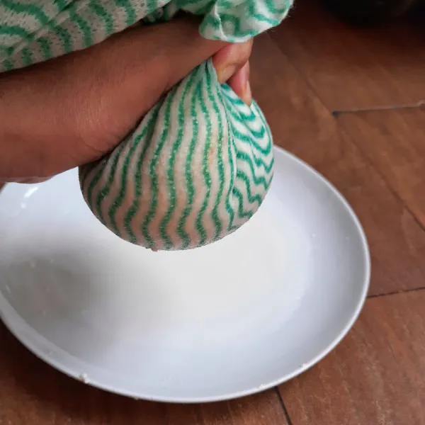 Bungkus tahu yang sudah halus tadi dengan serbet. Peras airnya hingga kesat. Proses ini dilakukan agar isian tahu nanti tidak terlalu lembek.