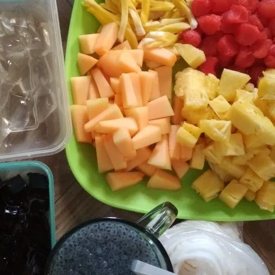 Siapkan bahan bahannya. Potong potong buah dengan bentuk sesuai selera. Rendam selasih dengan segelas air hingga selasih mengembang.