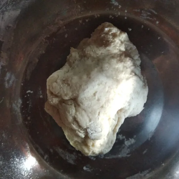 Tambahkan air hangat, tuang sedikit demi sedikit. Uleni hingga rata.
