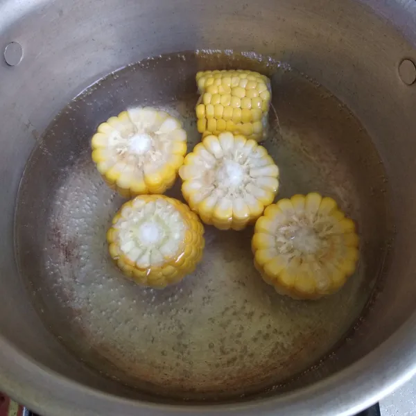 Didihkan air kemudian masukkan jagung manis, rebus sampai jagung setengah matang.