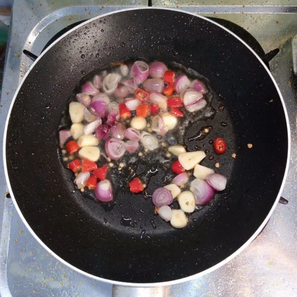 Tumis bawang merah,bawang putih dan cabai rawit sampai layu. Kemudian sisihkan minyaknya.