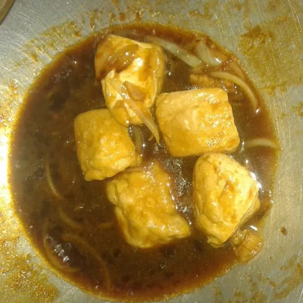 Masukkan tahu yang sudah digoreng tadi. Masak sampai bumbu meresap dan kuah mengental. Matikan api. Angkat.