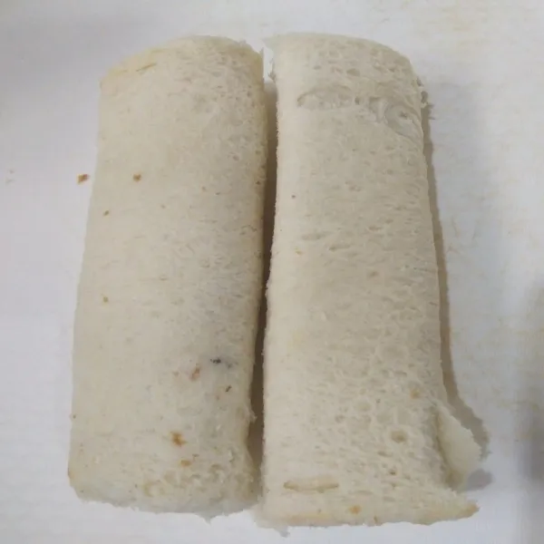 Gulung roti tawar yang sudah di isi pisang dan coklat.