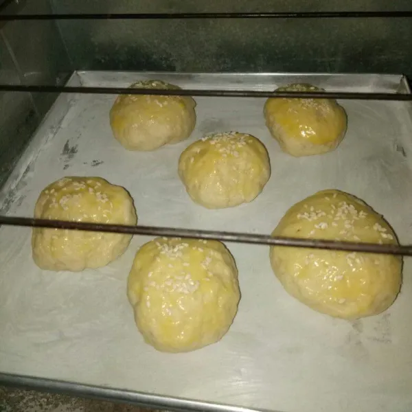 Setelah 1 jam dan mengembang, olesi bagian atas dengan margarin cair dan taburi wijen. Oven selama 20 menit, angkat dan dinginkan. Roti burger siap di gunakan.