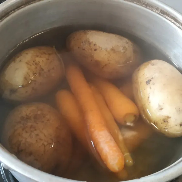 Cuci bersih kentang dan wortel. Rebus hingga empuk.