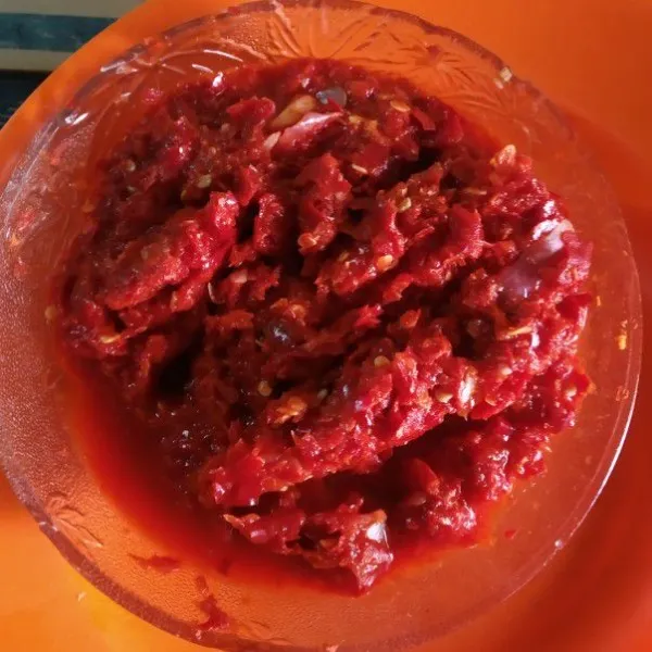 Haluskan cabe merah dan bawang.