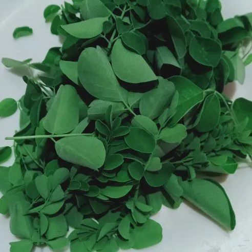 Pisahkan daun kelor dengan batangnya, lalu cuci bersih.