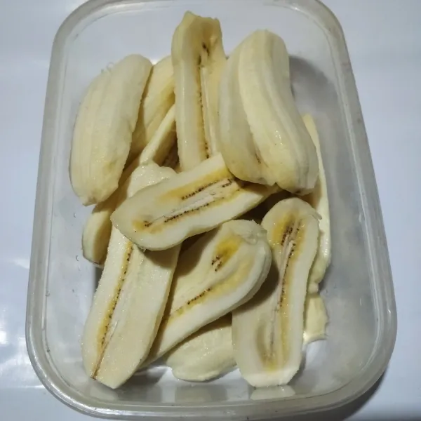 Potong masing-masing pisang menjadi 2 bagian.