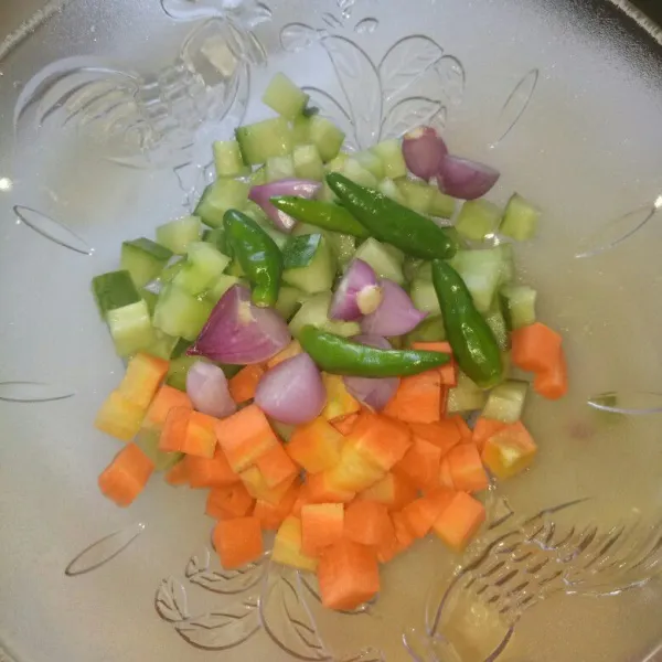 Siapkan wadah, potong dadu timun, wortel dan bawang merah. Cabe rawit dibiarkan utuh.