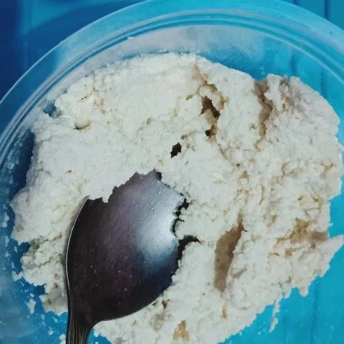 Tahu putih dihaluskan dengan sendok.