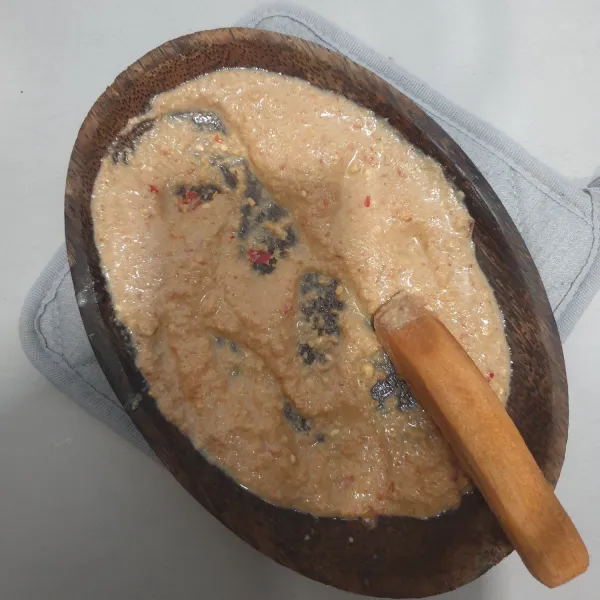Ulek cabe rawit, bawang putih, gula merah, garam dan kacang tanah goreng. Setelah halus masukkan asam jawa dan air ulek sampai tercampur rata, sisihkan.