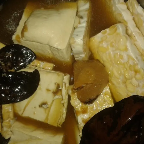 Masukkan tempe, tahu, bumbu halus, daun salam, lengkuas, garam, gula merah, air kelapa sampai tahu dan tempe terendam. Rebus sampai mendidih.