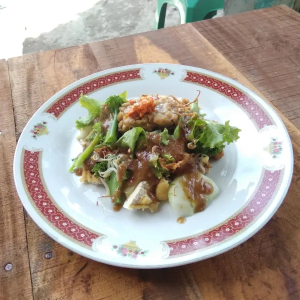 Siapkan piring saji, susun kentang, lontong dan bahan lainnya lalu siram dengan bumbu kacang.