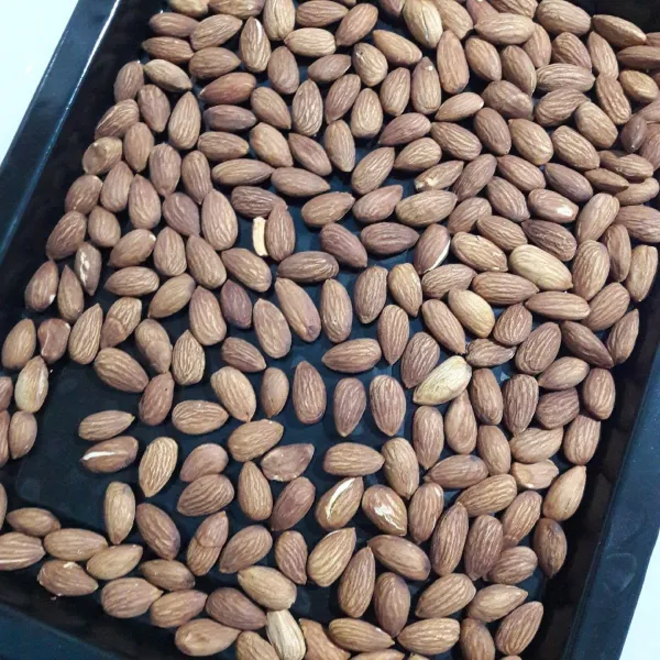 Keluarkan kacang almond dari oven, lalu tiriskan.