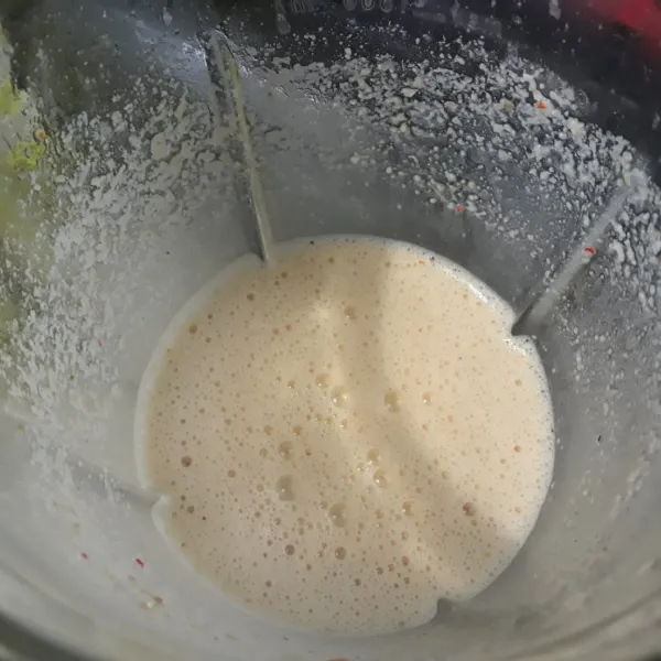 Masukkan kacang, cabai, bawang putih, daun jeruk, kencur, dan air dalam blender lalu blender hingga halus!