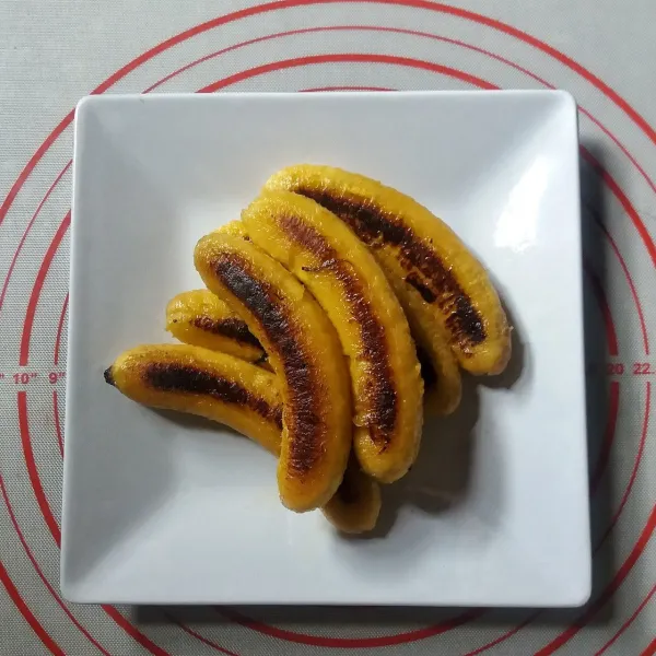 Angkat pisang yang sudah matang dari wajan dan pindahkan kepiring saji.