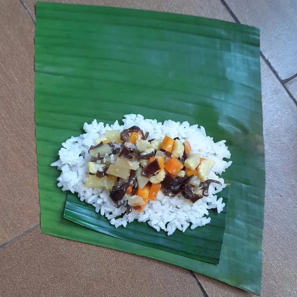 Penataan: siapkan daun pisang, beri nasi, letakkan isi di atas nasi.