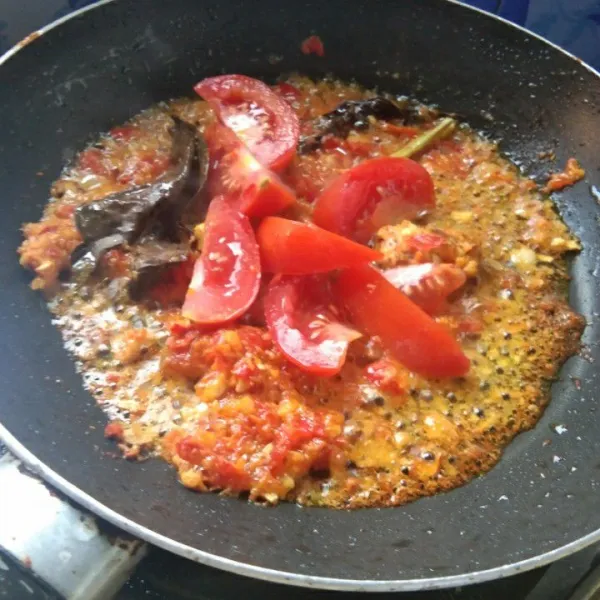 Tambahkan irisan tomat, masak hingga tomat layu.