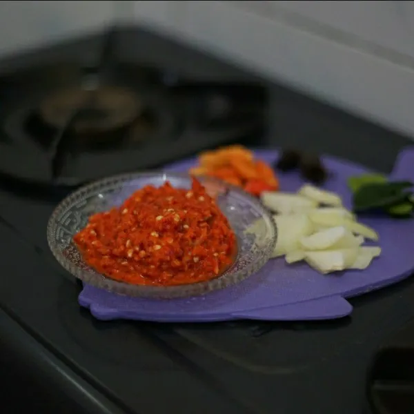 Haluskan cabai, bawang merah, bawang putih. Iris bawang bombay dan cabai rawit merah untuk tumisan