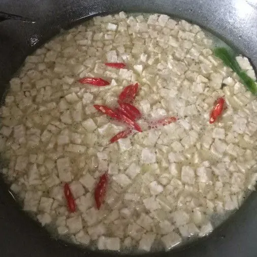 Kemudian masukkan air bersih, tempe dan irisan cabai merah keriting. Aduk rata dan didihkan.