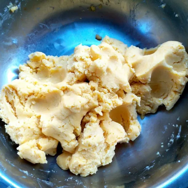 Campur tepung dengan kuning telur, uleni dan lanjut masukkan sedikit demi sedikit margarin, campur hingga rata