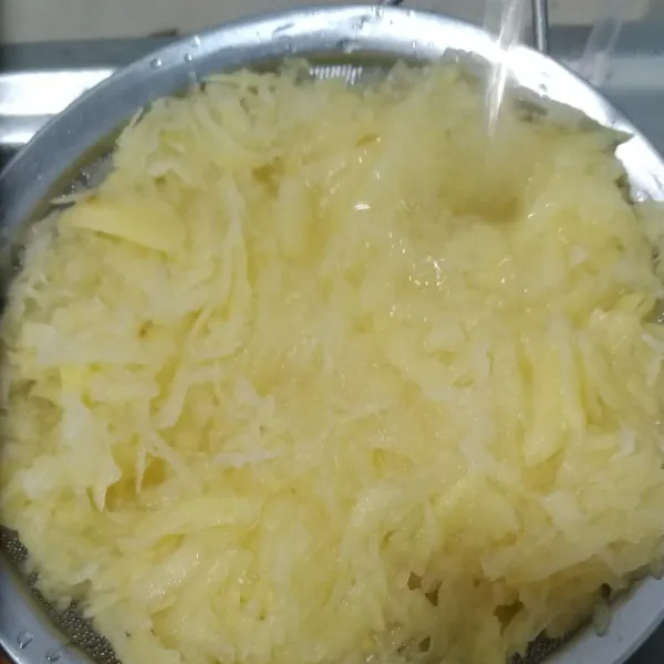 Bilas kentang parut 2-3 kali agar patinya berkurang sehingga lebih renyah. Kemudian peras-peras kentang dalam saringan, masukkan ke dalam wadah.