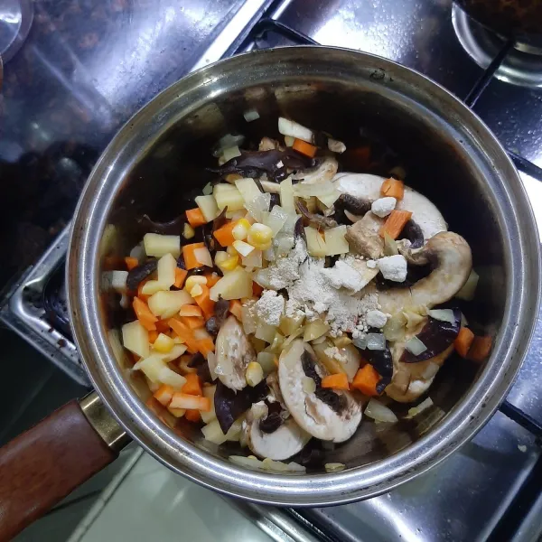 Masukkan semua jamur tumis hingga jamur champignon agak layu. Lalu masukkan wortel, kentang, sisa jagung pipil, bawang putih bubuk dan bawang bombay bubuk. Aduk hingga rata.