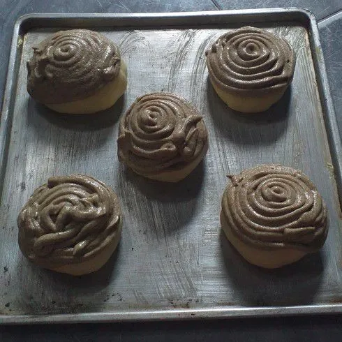 Setelah proofing 1 jam, potong ujung plastik toping. Kemudian letakkan melingkar di atas adonan hingga menutupi 1/2 permukaannya