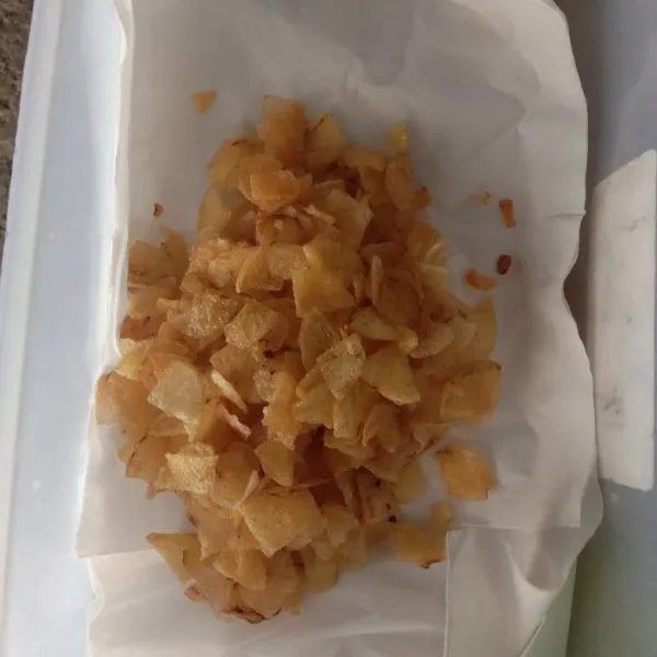 Letakkan keripik kentang yang sudah ditiriskan dalam wadah yang dilapisi tissue