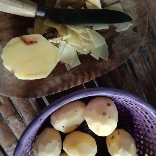 Kupas kentang, cuci bersih. Potong kentang jadi 4 bagian, iris tipis
