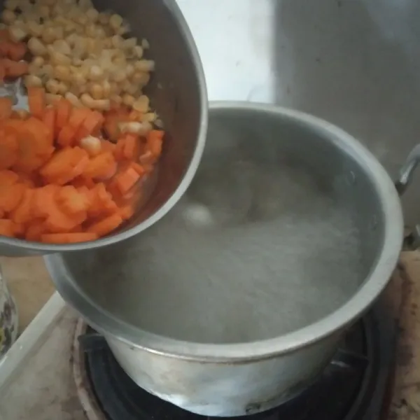 Setelah mendidih, masukkan bumbu geprek, wortel dan jagung, rebus hingga empuk. Masukkan sawi putih, aduk hingga layu.