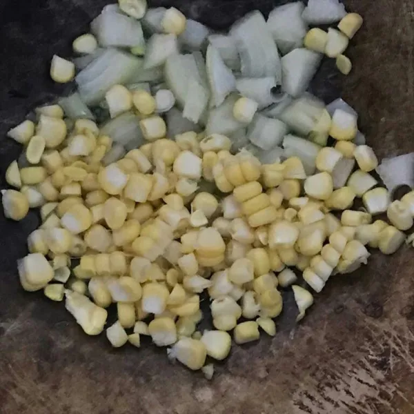 Panaskan kompor dengan api sedang cenderung kecil. Masukkan minyak sayur, setelah itu bawang bombay dan jagung manis. Aduk dan tes kematangan jagung.