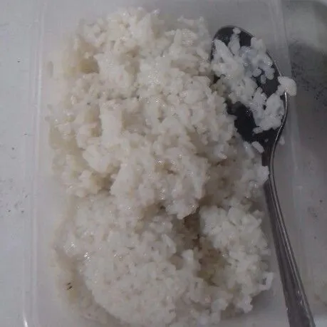 Ambil nasi yang baru saja matang. Letakkan dalam kotak makan.