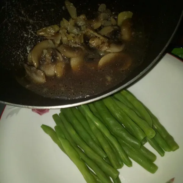 Tata buncis pada piring saji, siram dengan kuah jamur. Sajikan.