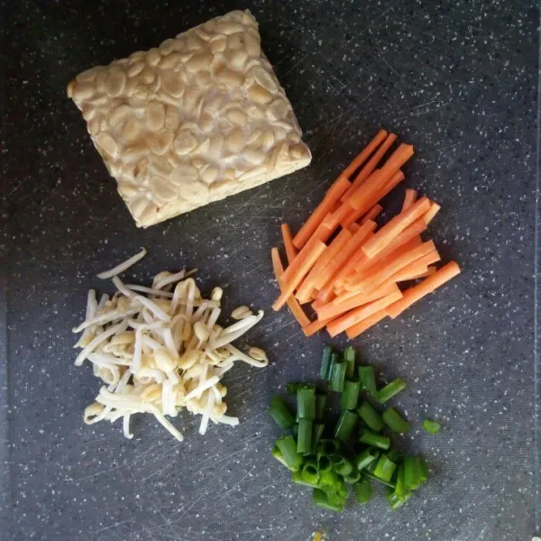 Siapkan tempe, wortel yang dipotong korek api. Tauge yang dibuang akarnya dan daun bawang iris halus.