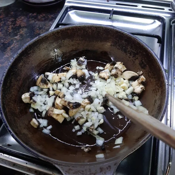 Tumis bawang dan jamur champignon hingga jamur berubah warna.