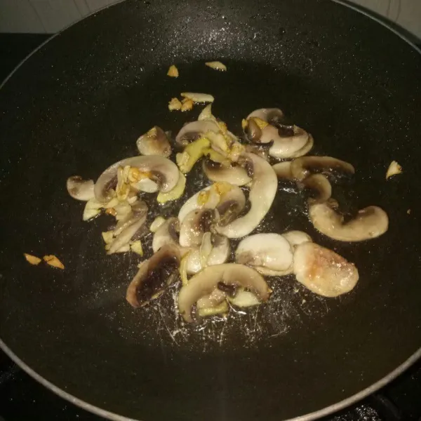 Siapkan pan, panaskan minyak. Tumis bawang putih dan jahe sampai harum, masukkan jamur. Aduk rata sampai jamur layu.