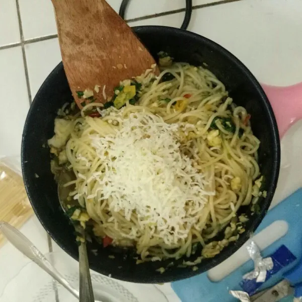 Masukkan spaghetti yang telah direbus dan beri sedikit parutan keju (sesuai selera masing-masing), aduk, dan tunggu hingga matang sempurna