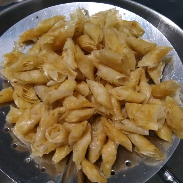 Siapkan wajan tuang minyak panaskan, lalu goreng potongan kulit lumpia, dibolak-balik tunggu sampai garing, berubah warna kuning keemasan, angkat, tiriskan dan sisihkan.