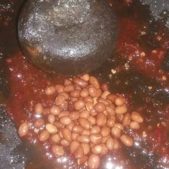 Lalu tambahkan kacang tanah goreng, ulek kacang hingga tercampur rata dengan bumbu, tapi jangan sampai terlalu halus.