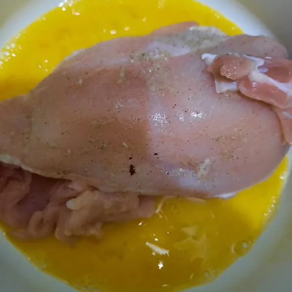Celupkan ayam di dalam kocokan telur dan susu cair