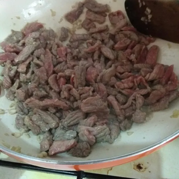Masukkan daging sapi, masak hingga berubah warna.